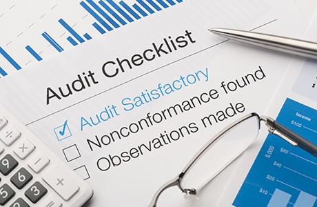 Audit checklist on a desk, with tick against audit satisfactory